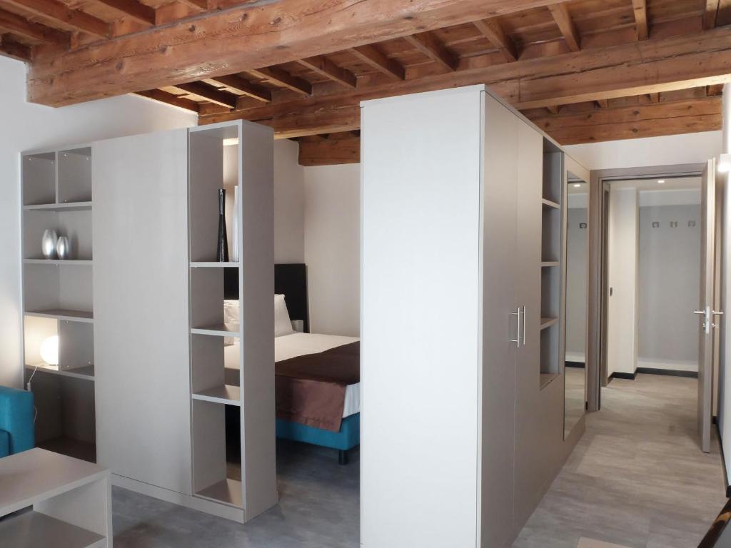 フェラーラにあるResidence Carltonの白い壁のベッドルーム1室、ベッド1台が備わります。