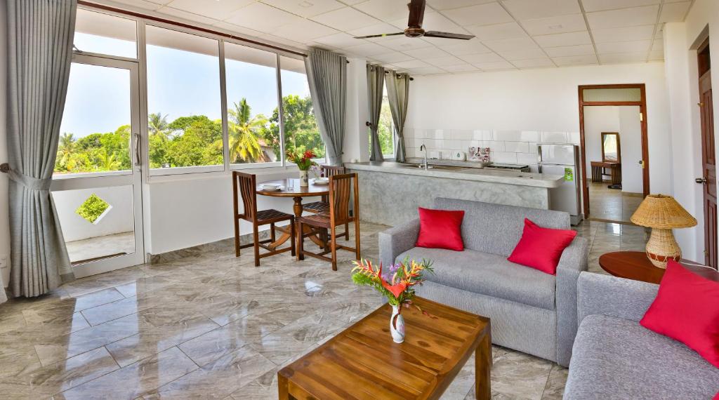 Villa Gamini في هيكادوا: غرفة معيشة مع أريكة وطاولة