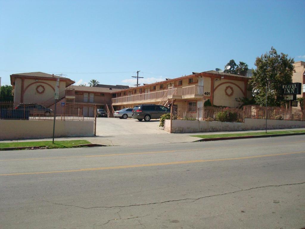 an empty street in front of a building with a parking lot at Travel Inn in Los Angeles