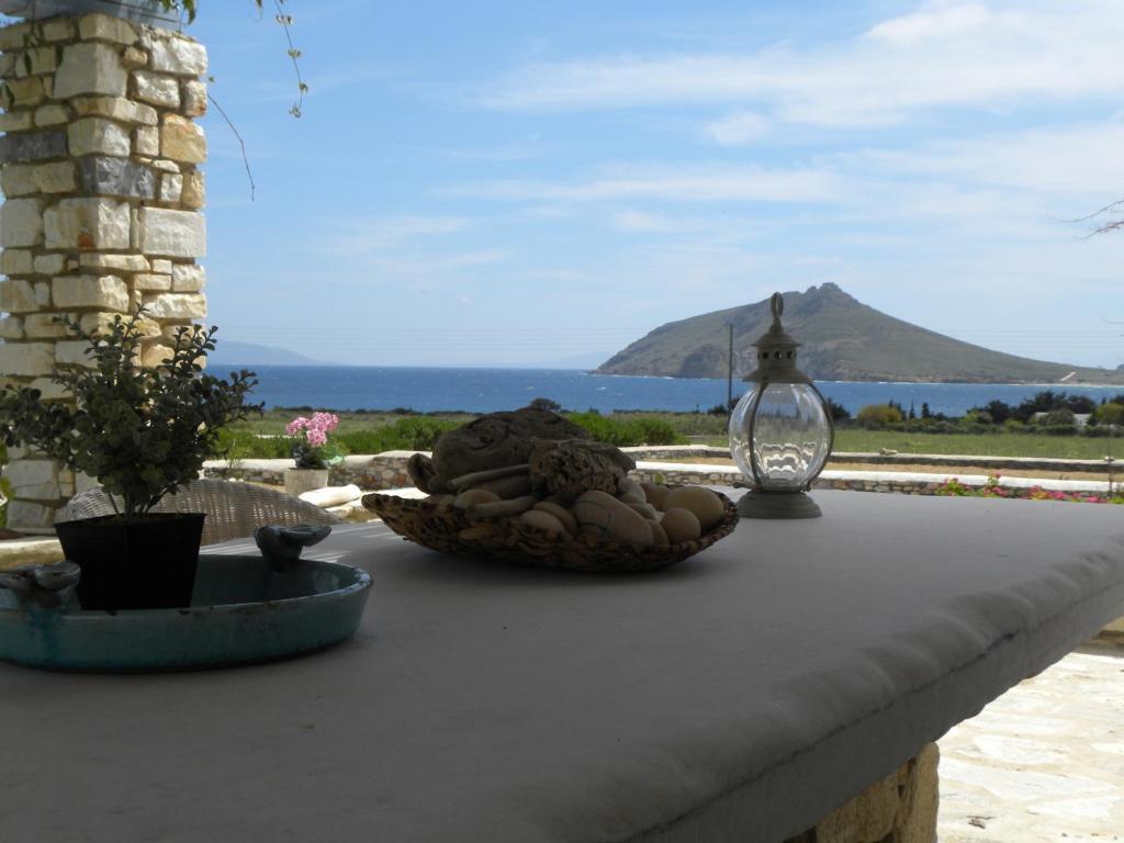 a table with a bowl of food on it with a view of the ocean at Villa Petradi (150 meters from the sea) in Ambelas