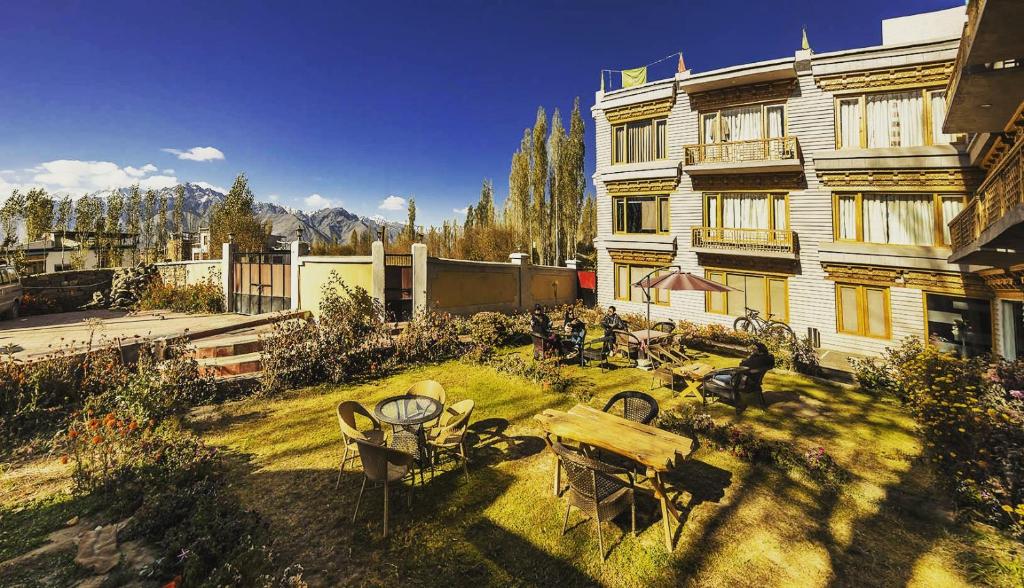 a yard with tables and chairs in front of a building at Yarab Tso in Leh