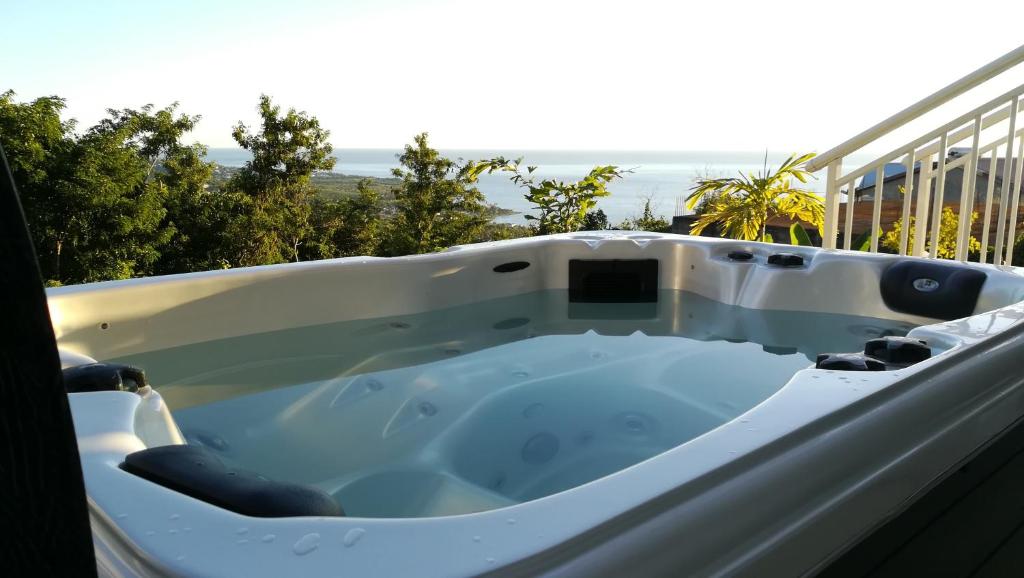a bath tub sitting on top of a balcony at Côté Caraïbes in Bouillante