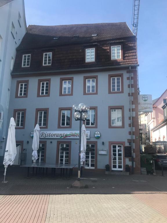 ein großes Gebäude mit Sonnenschirmen davor in der Unterkunft Münch 10 in Kaiserslautern