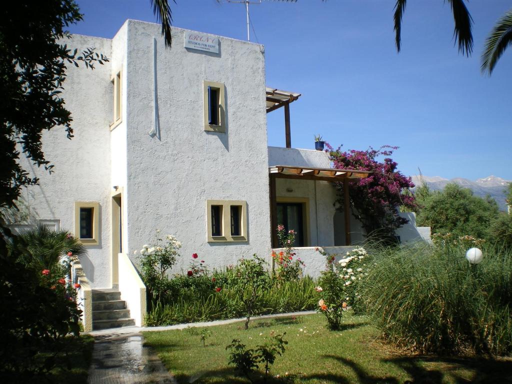 una casa blanca con un jardín delante de ella en Irini Studios en Georgioupolis