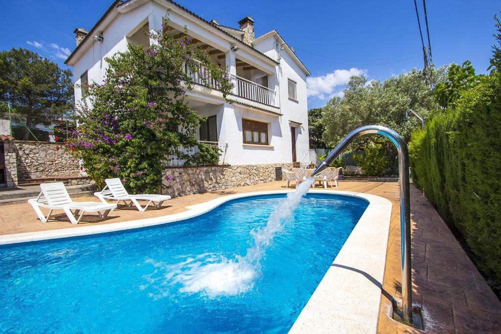 a pool with a water fountain in front of a house at Casa De Vacaciones "CAL VIVES" in Canyelles