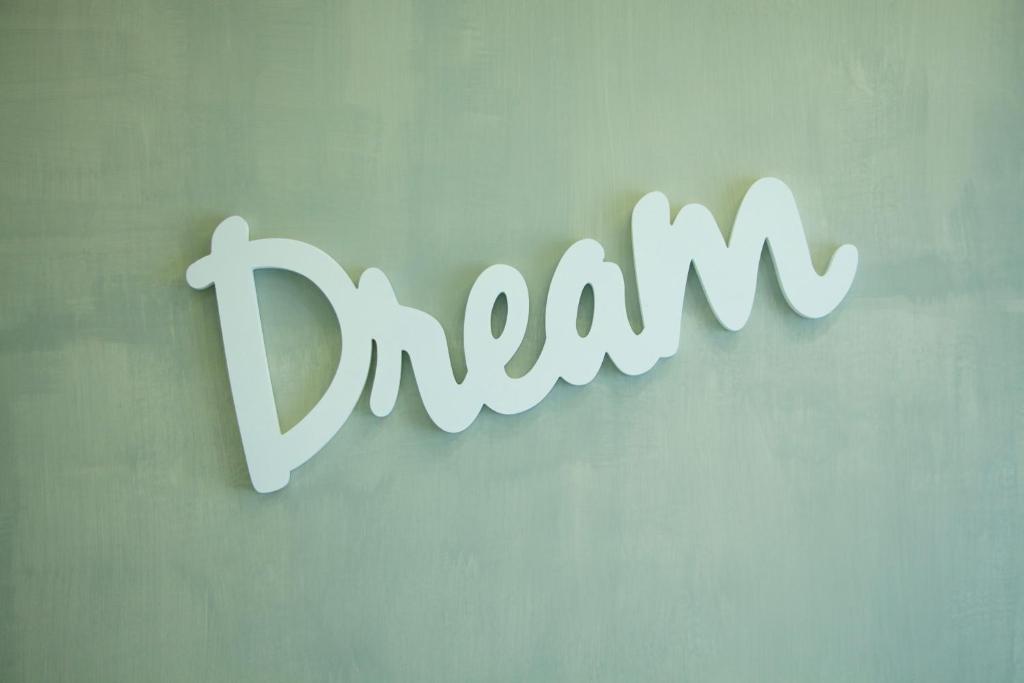 een teken voor het woord droom hangend aan een muur bij Recia Room in Napels