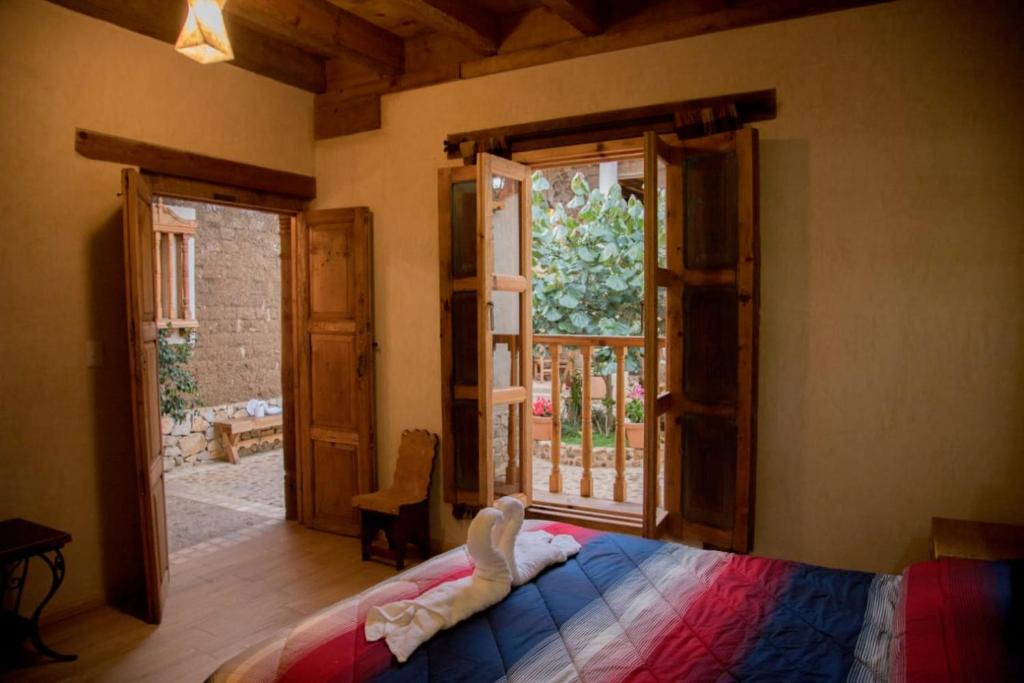 um quarto com uma cama e uma janela aberta em Hotel Casa de Gandhi em San Cristóbal de Las Casas