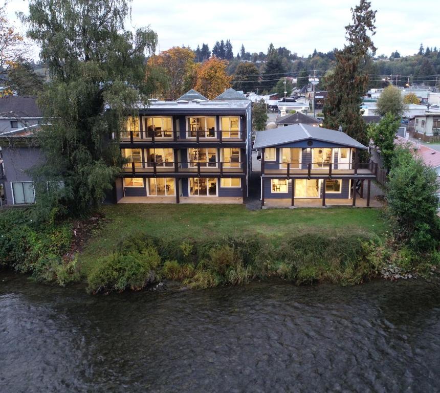 a large house on a hill next to a river at Chateau Riverside in Campbell River
