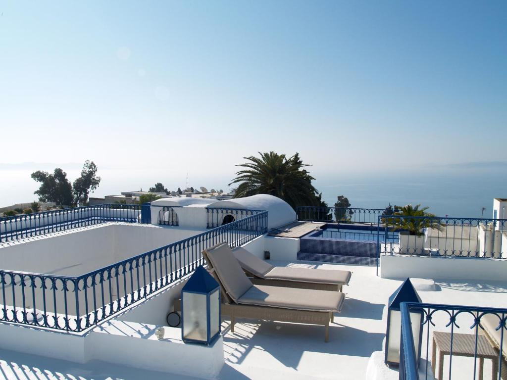 a resort with a pool and chairs and the ocean at Dar Fatma in Sidi Bou Saïd
