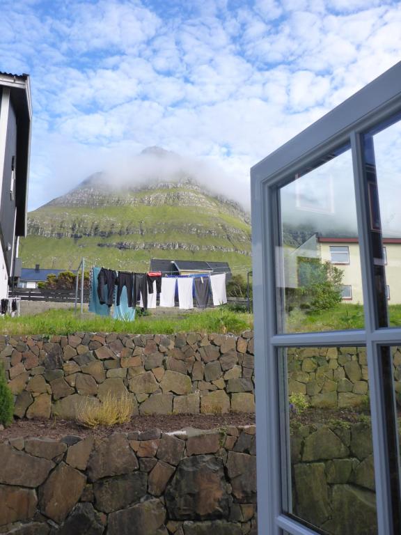 an open window with a view of a mountain at visitHOMES Faroe Islands in Leirvík