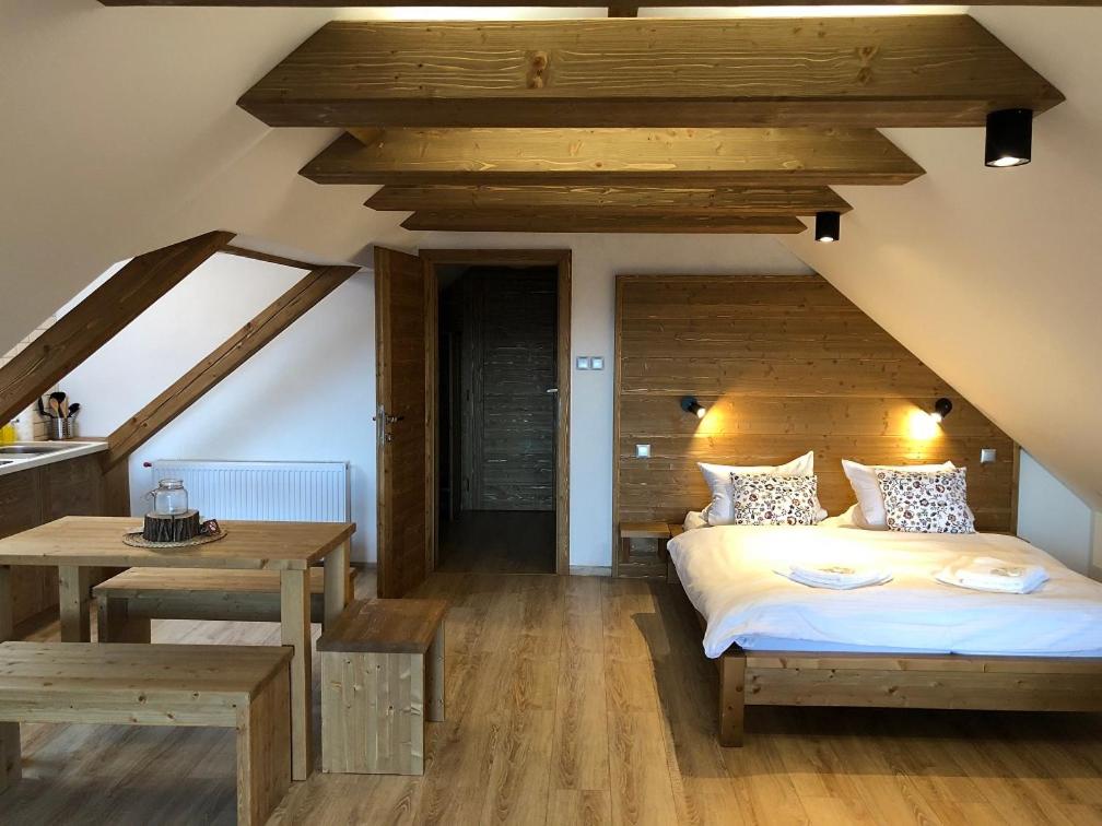 1 dormitorio con cama y techo de madera en Apartmány Nad Pivovarem, en Havířov