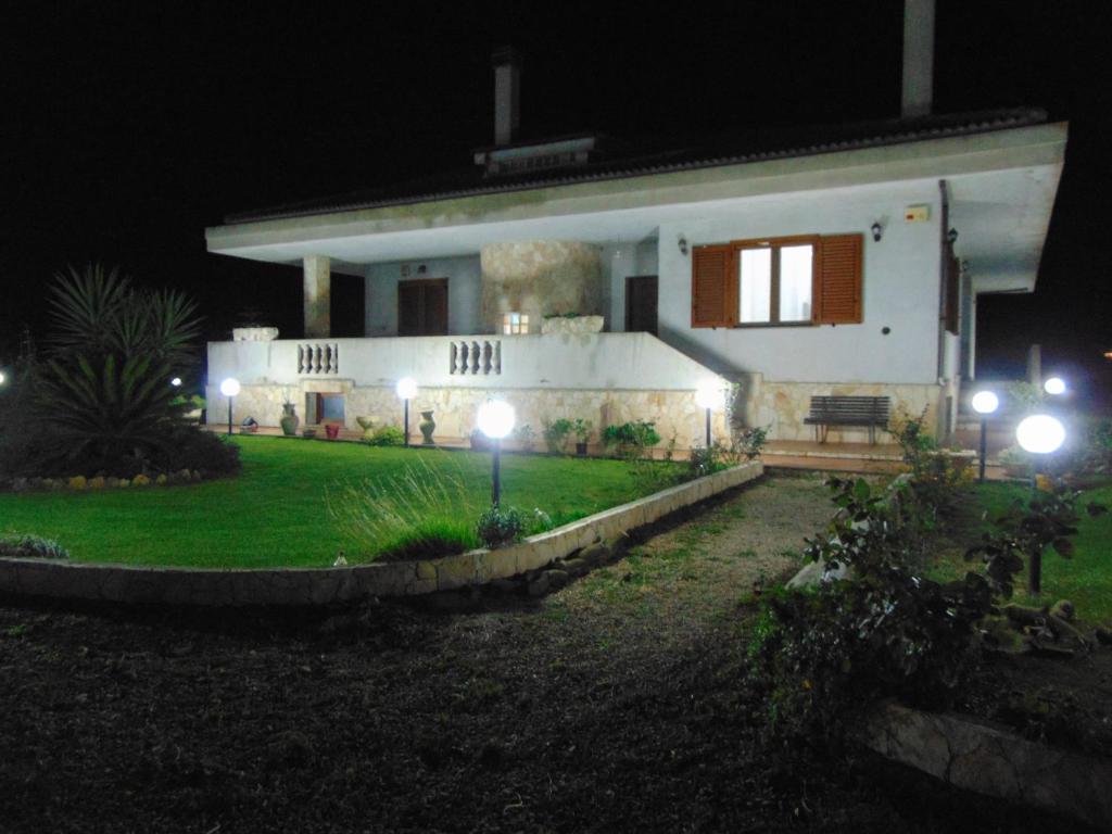 una casa blanca con luces delante de ella por la noche en Da Mario & Marianna en Campanedda