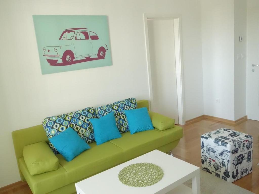 una sala de estar con un sofá verde con almohadas azules en Your Place in Zagreb, en Zagreb