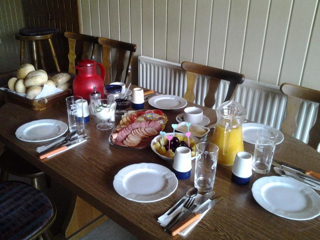 a wooden table with plates of food on it at Zur alten Eiche in Stepenitz