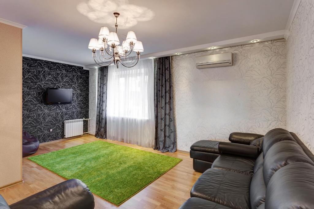 カザンにあるTihomirnova apartmentsのリビングルーム(革張りのソファ、緑の敷物付)