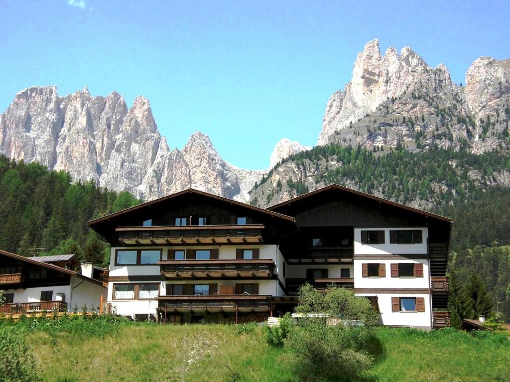 ein Gebäude vor einem Berg in der Unterkunft Residence La Zondra in Pozza di Fassa