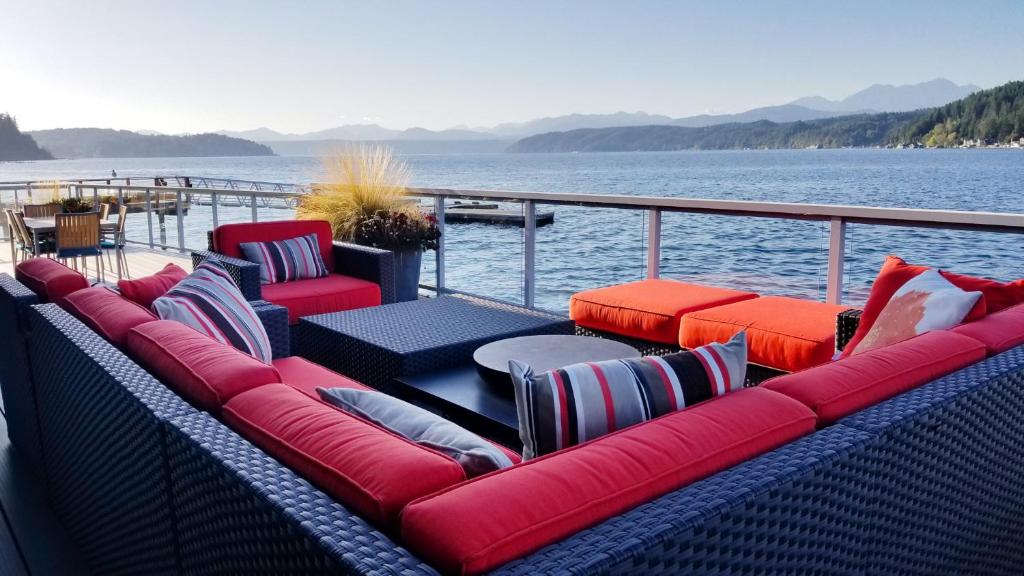 a group of red chairs and tables on a boat at Walls of Glass Hood Canal Vacation Rental in Union