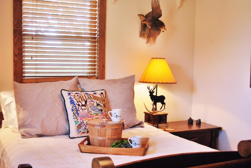 Schlafzimmer mit einem Bett und einem Tisch mit einer Lampe in der Unterkunft Glory Hills Ranch in Pipe Creek