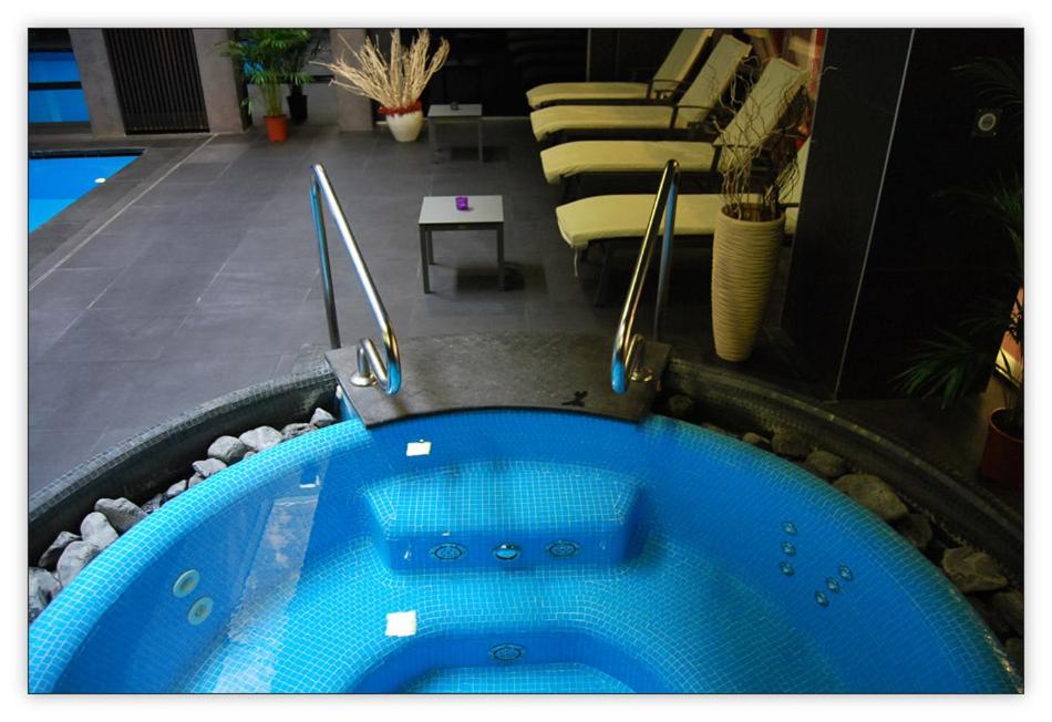 een blauwe hot tub in een kamer met een woonkamer bij Imperial Suites in Boedapest