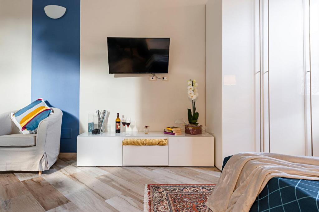 a living room with a white cabinet and a tv on a wall at Minerva Apartment in Casciana Terme