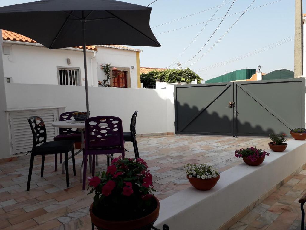 a patio with a table and chairs and an umbrella at A Casinha in Sintra