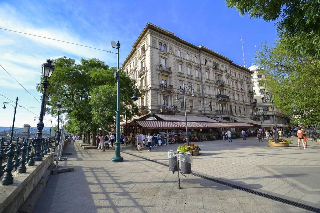 duży budynek na ulicy z ludźmi chodzącymi dookoła w obiekcie Vigadó Square Panorama Apartment w Budapeszcie