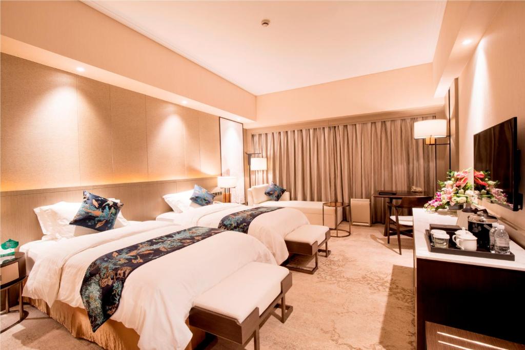 Postel nebo postele na pokoji v ubytování Jin Jiang Pine City Hotel