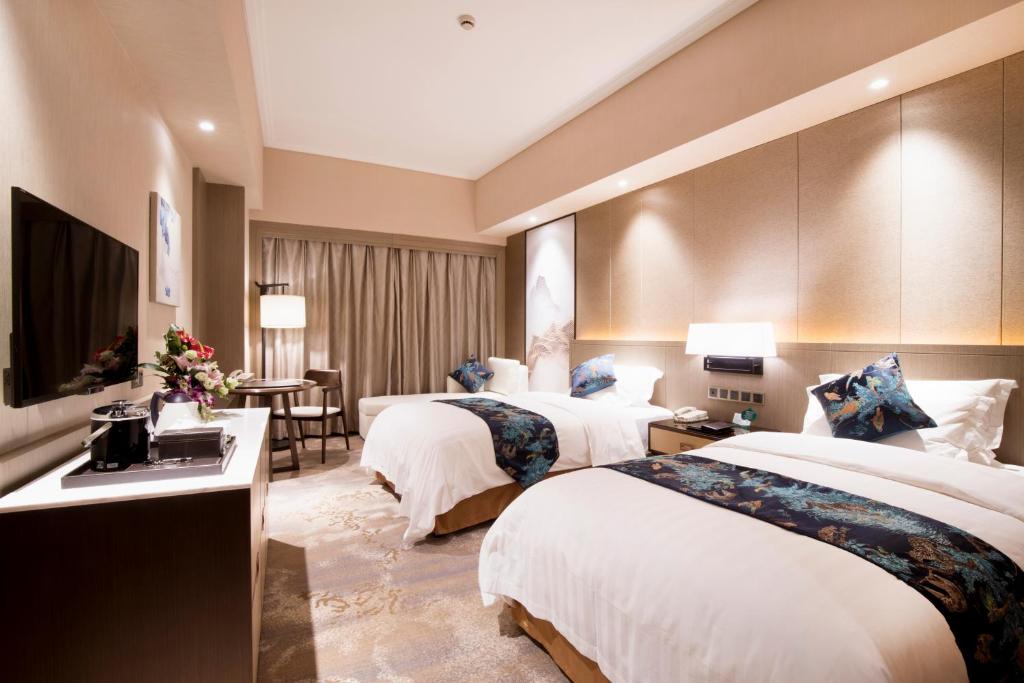 Postel nebo postele na pokoji v ubytování Jin Jiang Pine City Hotel