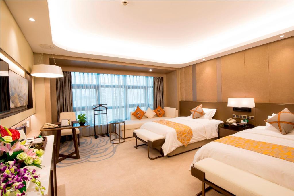 Postel nebo postele na pokoji v ubytování Jin Jiang Pine City Hotel