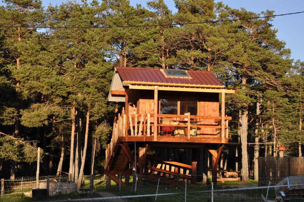 a tree house with a red roof at Cabane des Guernazelles in Valderoure