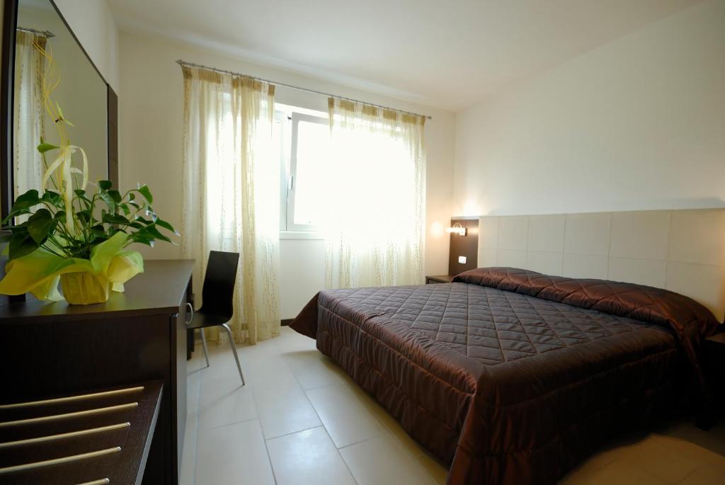 een slaapkamer met een bed, een bureau en een raam bij Casa Piccola Torbole in Nago-Torbole