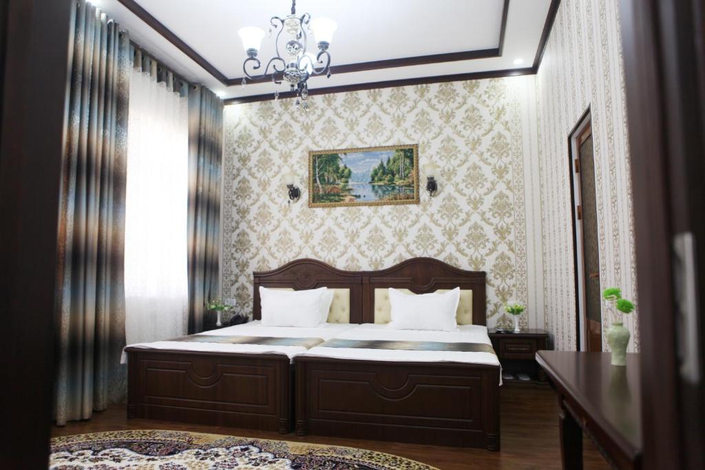um quarto com uma cama e um lustre em Hotel Naxshab em Carxi