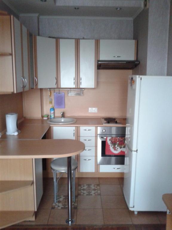 イルクーツクにあるApartment on Sovetskaya 96の小さなキッチン(白い冷蔵庫、テーブル付)