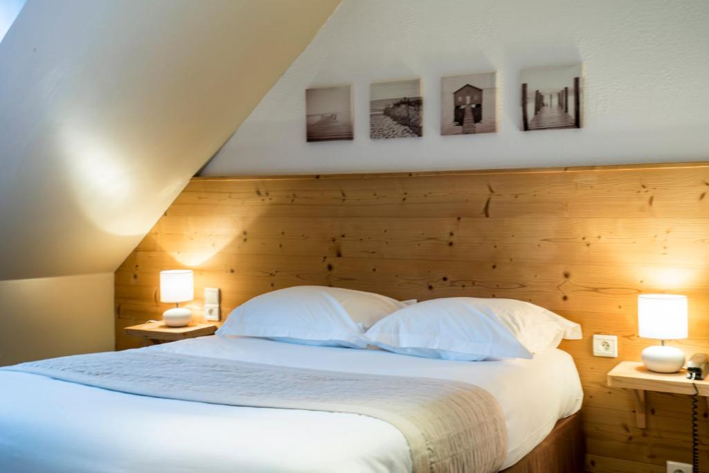 um quarto com uma grande cama branca e 2 candeeiros em Hôtel Saint-Pierre em Pontarlier