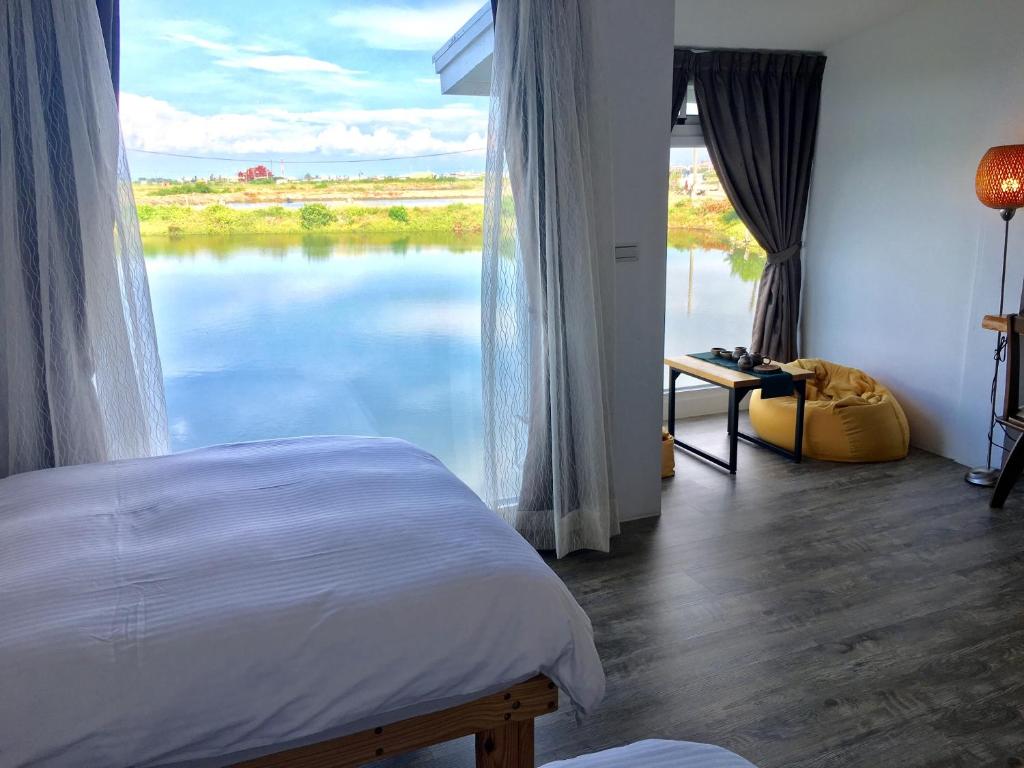 1 dormitorio con ventana grande con vistas al lago en Lan People Villa en Qigu