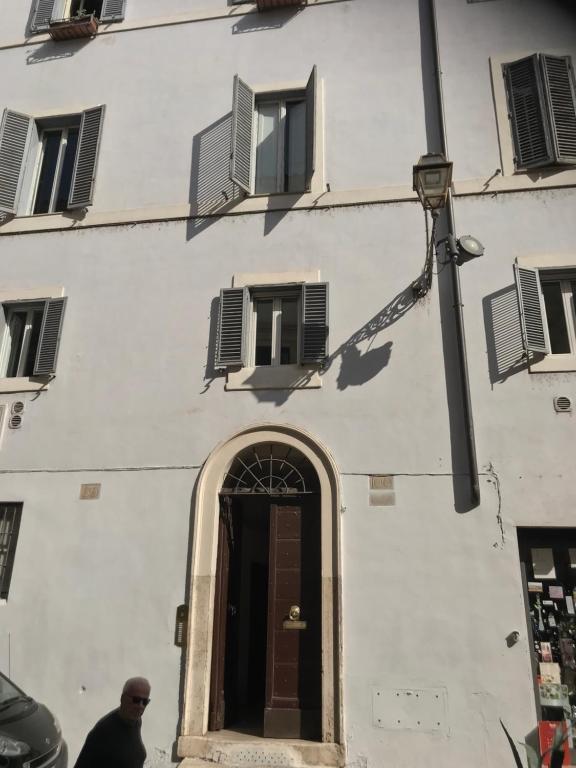 a man standing in front of a white building at La casa dell'Arte nel cuore di Roma in Rome