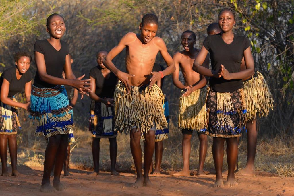 een groep mensen die in de modder staan bij RiverDance Lodge in Mamono