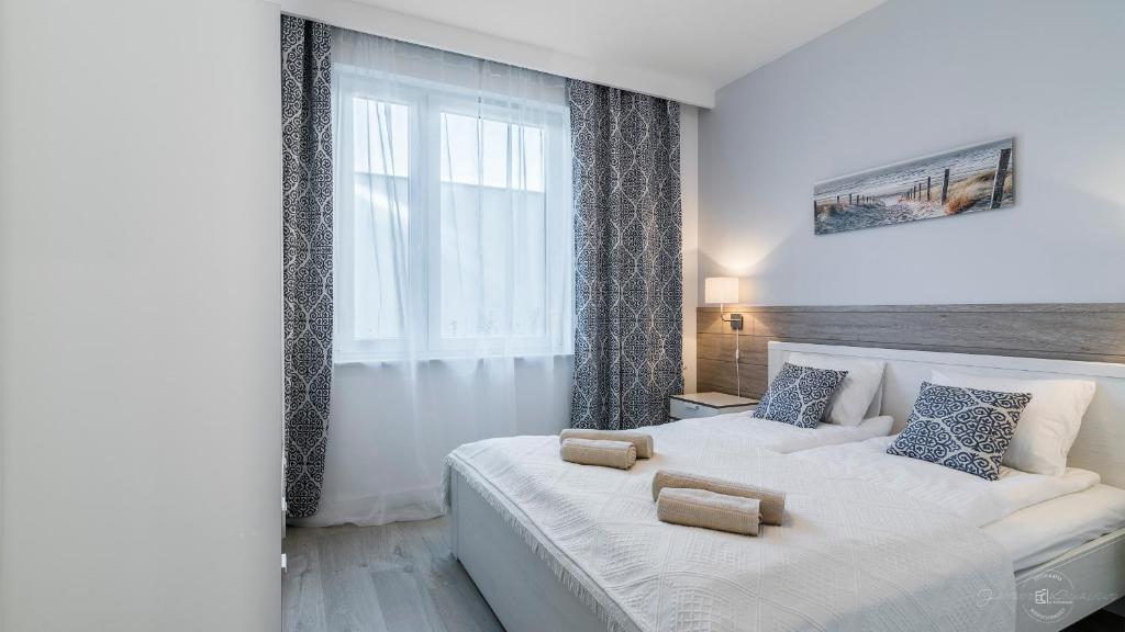 グダニスクにあるhvile 104 - Gdańsk TRE MAREの白いベッドルーム(大型ベッド1台、窓付)