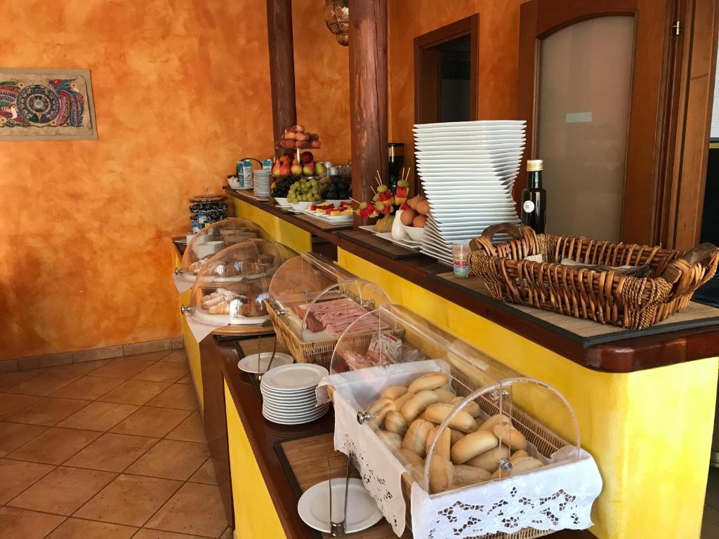 a buffet line with plates and baskets of food at El Mosaico Del Sol in Lampedusa
