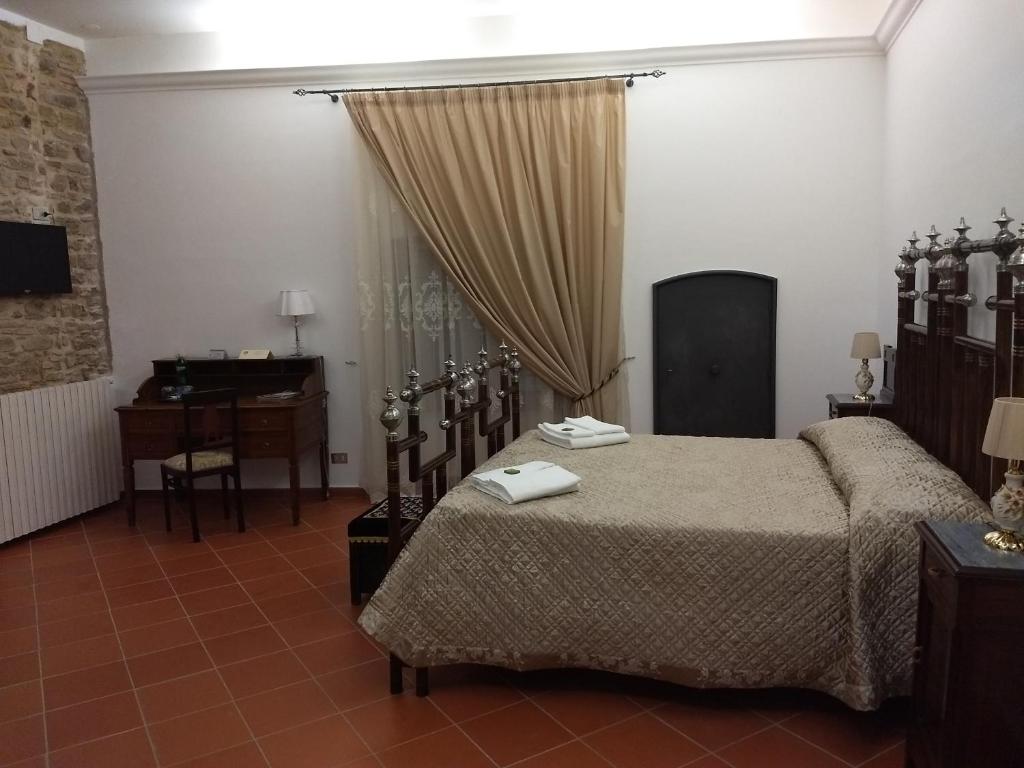 una camera con letto, scrivania e finestra di Castel di Pietra a Pietra Montecorvino