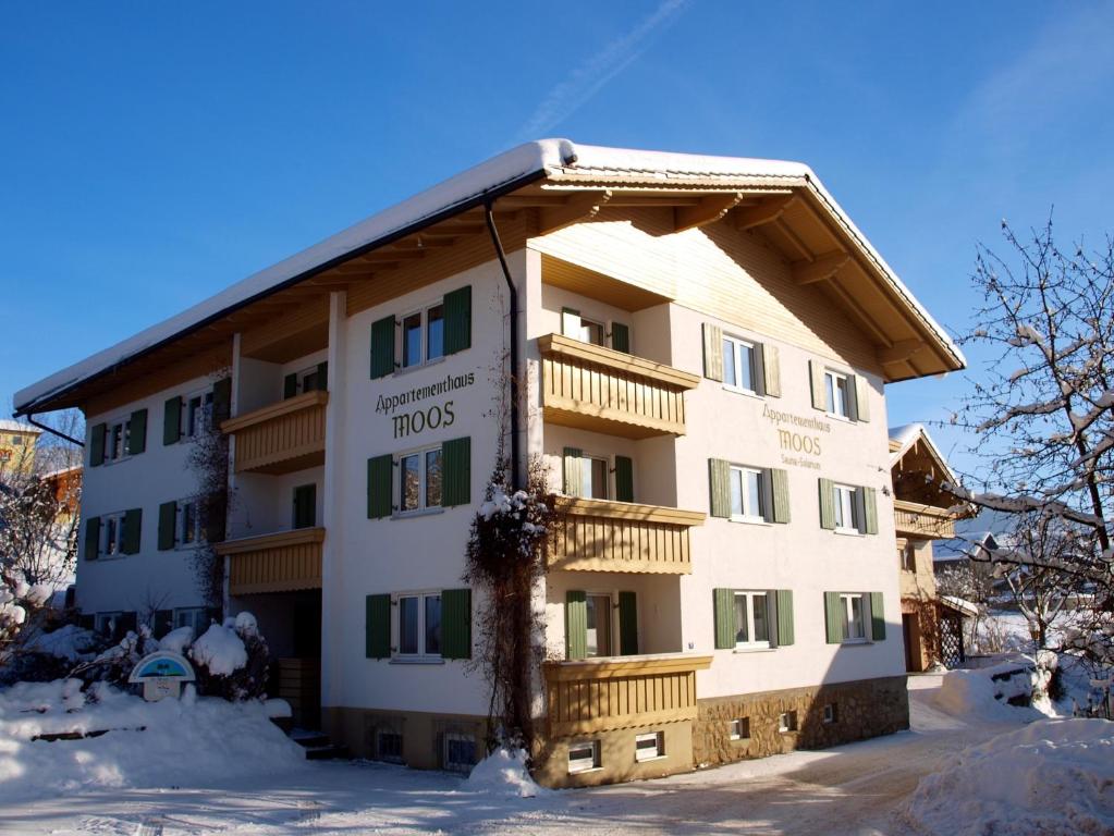 un hotel en invierno con nieve en el suelo en Appartementhaus Moos, en Lam