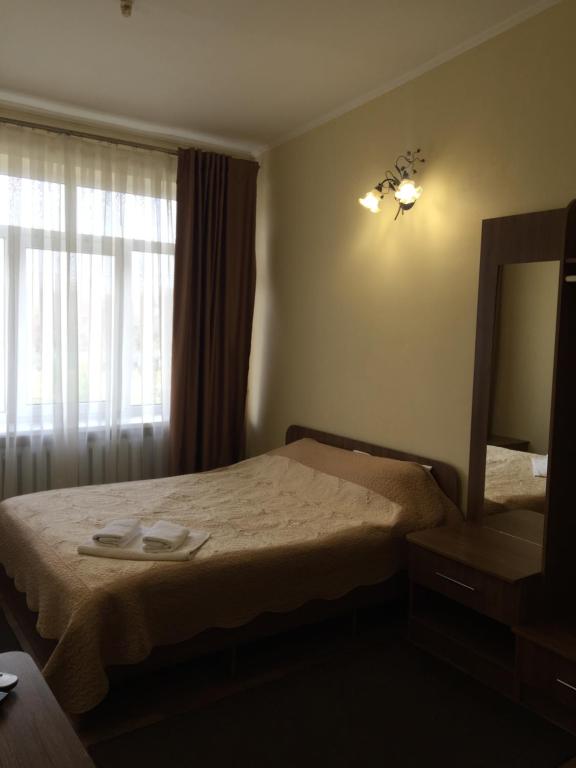 a bedroom with a bed and a mirror and a window at DOLCHE VITA in Berkhomet-pe-Siret