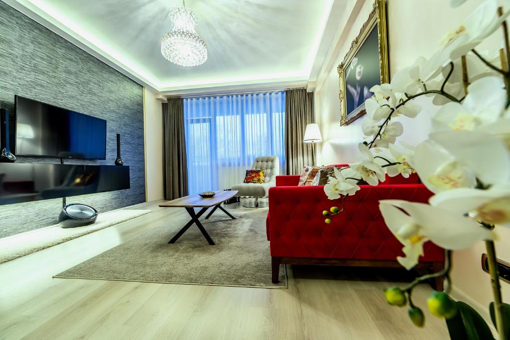 a living room with a red couch and a tv at Apartment Chic by Landev in Braşov