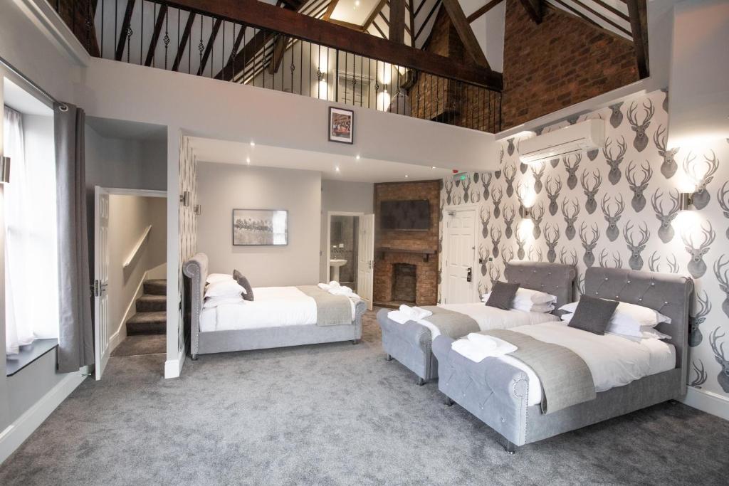 two beds in a large room with white walls at The Glebe Hotel in Liverpool