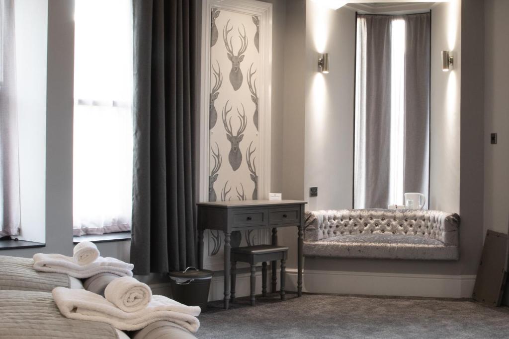 a bedroom with a bed and a table with towels at The Glebe Hotel in Liverpool