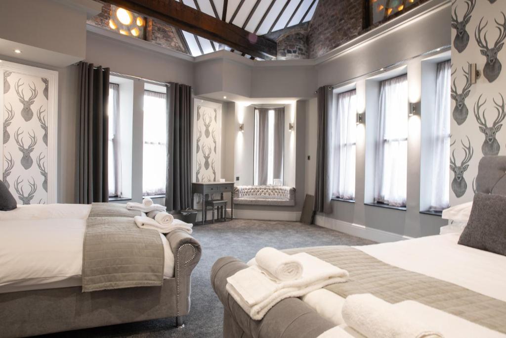 a bedroom with two beds and large windows at The Glebe Hotel in Liverpool
