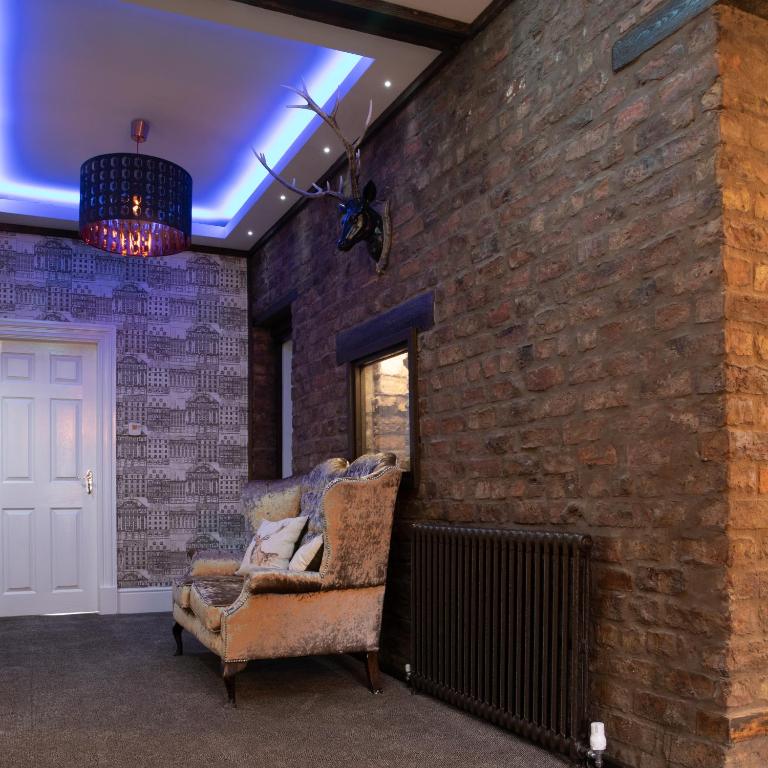 a brick wall with a chair in a room at The Glebe Hotel in Liverpool