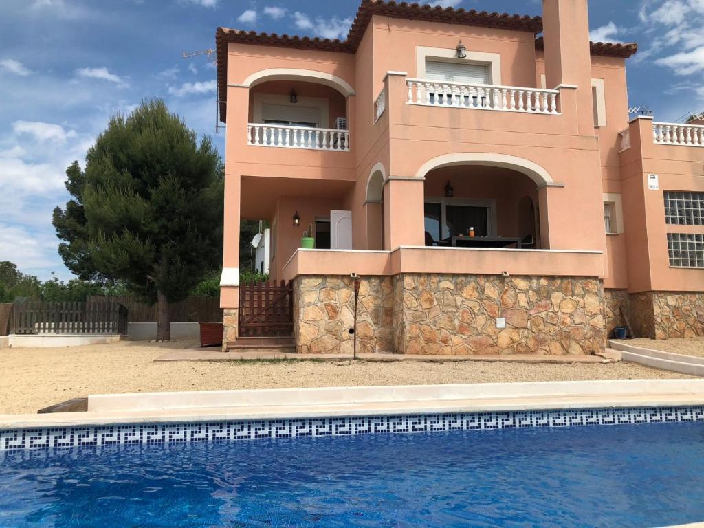 a house with a swimming pool in front of it at CASA BRISA in Les tres Cales