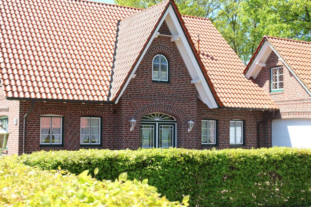 a brown brick house with an orange roof at Ferienwohnung an der Mühle in Bad Zwischenahn
