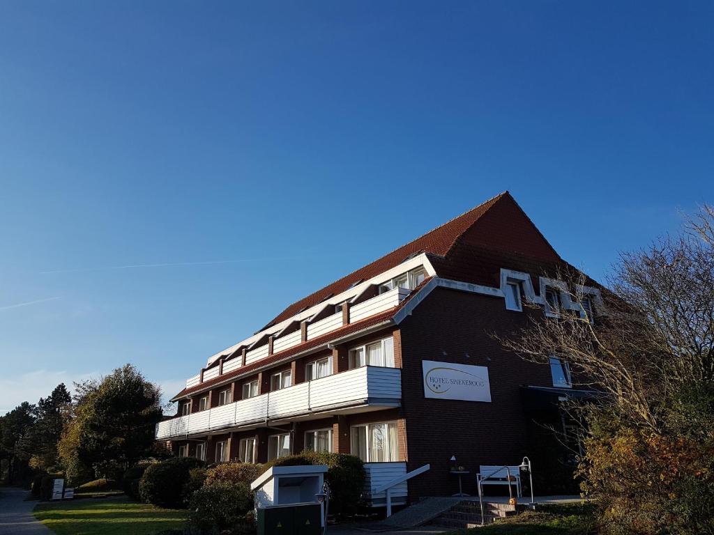 un bâtiment brun avec un panneau sur son côté dans l'établissement Hotel Spiekeroog, à Spiekeroog